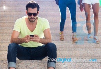 Young Man Using His Mobile Phone In The Street Stock Photo