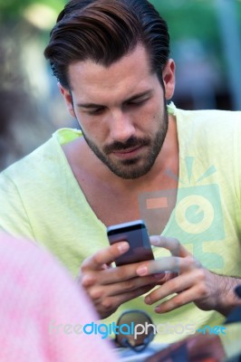 Young Man Using His Mobile Phone In The Street Stock Photo