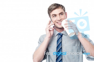 Young Man Using His Mobile While Drinking Coffee Stock Photo