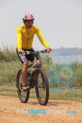 Young Man Wearing Rider Suit Riding Mountain Bike Mbt On Dusty R… Stock Photo