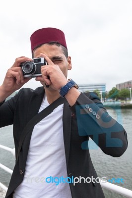 Young Man With A Fez Cap Taking A Photo Stock Photo