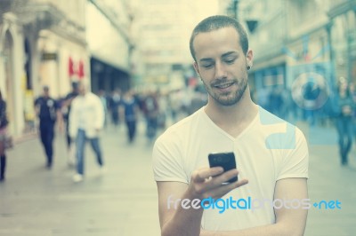 Young Man With Cell Phone Walking Stock Photo