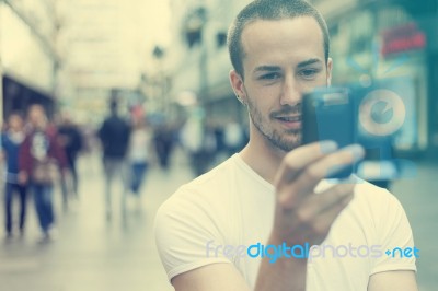 Young Man With Cell Phone Walking Stock Photo