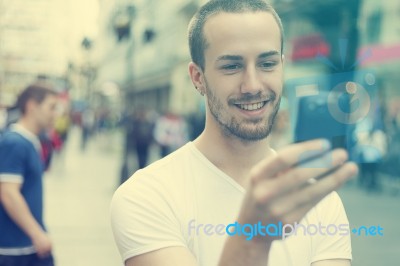 Young Man With Cell Phone Walking Stock Photo