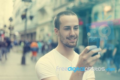 Young Man With Cell Phone Walking Stock Photo