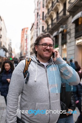 Young Man With Glasses And  Bearded Talking On His Smartphone Stock Photo