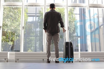 Young Man With Luggage Waiting At Airport Stock Photo