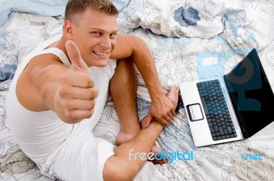 Young Man With Thumbs Up And Laptop Stock Photo