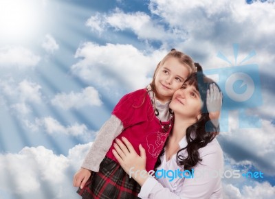 Young Mother And Her Little Daughter Look Up On A Background Clo… Stock Photo