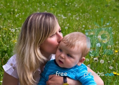 Young Mother Kisses Her Little Son Stock Photo