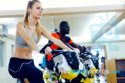 Young People With Fitness Bicycle In The Gym Stock Photo