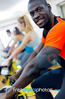 Young People With Fitness Bicycle In The Gym Stock Photo