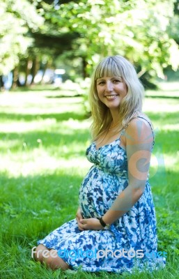 Young Pregnant Woman In City Park Stock Photo