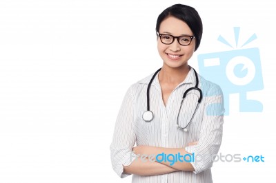 Young Pretty Female Doctor With Arms Folded Stock Photo