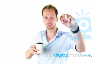 Young Salesman Holding Cup And Coffee Beans Stock Photo