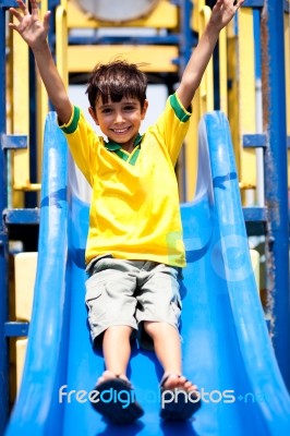 Young Smart Kid Sliding Down The Swing Stock Photo