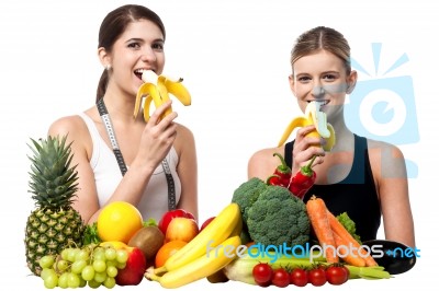 Young Smiling Girls Eating Banana Stock Photo