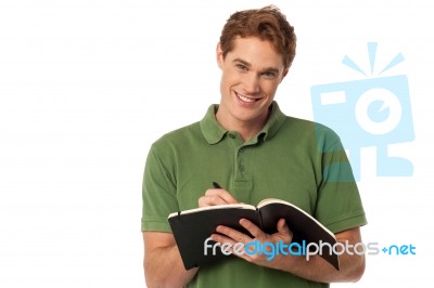 Young Student Writing On The Notebook Stock Photo