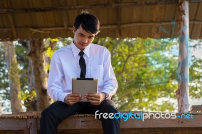 Young Students Use Tablets On Bamboo Houses In The Countryside Stock Photo