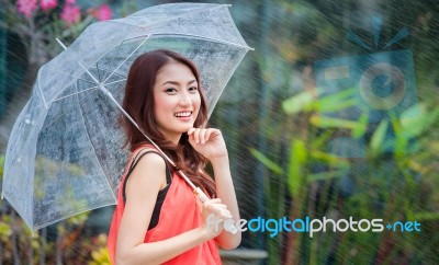 Young Thai Lady Standing With Under Umbrella Stock Photo