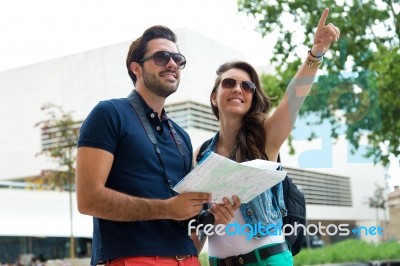 Young Tourist Couple Use Their Map And Pointing Where They Want Stock Photo