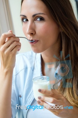 Young Woman At Home Eating Yogurt Stock Photo