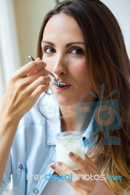 Young Woman At Home Eating Yogurt Stock Photo