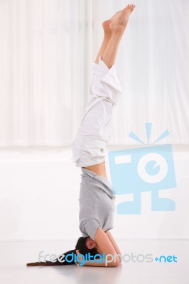 Young Woman Doing Yoga Headstand Pose Stock Photo