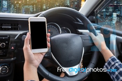 Young Woman Driver Using Touch Screen Smartphone And Hand Holding Steering Wheel Stock Photo