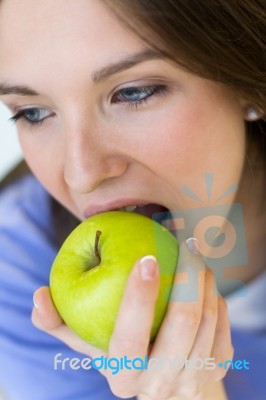 Young Woman Eating Green Apple Stock Photo