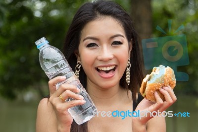 Young Woman Enjoying A Chicken Burger Stock Photo