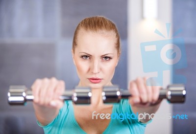 Young Woman Exercising With Dumbbells At The Gym Stock Photo