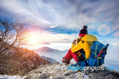 Young Woman Hiker Taking Photo With Smartphone On Mountains Peak In Winter Stock Photo