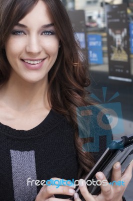 Young Woman Holding A Tablet On The Street Stock Photo