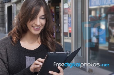 Young Woman Holding A Tablet On The Street Stock Photo