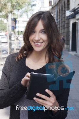 Young Woman Holding A Tablet On The Street Stock Photo