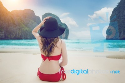 Young Woman In Red Bikini Sitting On The Beach Stock Photo