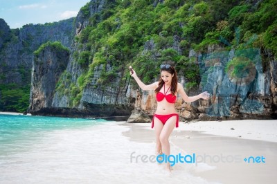 Young Woman In Red Bikini Sitting On The Beach Stock Photo