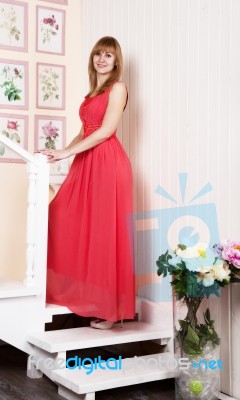 Young Woman In Red Dress Standing On The Stairs Stock Photo