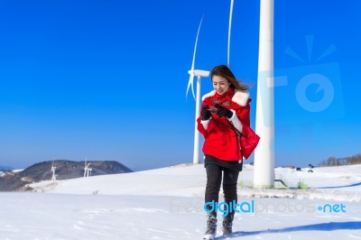 Young Woman Is A Happiness With Camera In Winter Of Sky And Winter Road With Snow And Red Dress Stock Photo