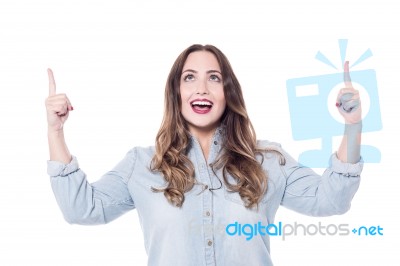 Young Woman Pointing Upwards Stock Photo