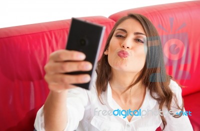 Young Woman Puckering While Taking Selfie On Sofa Stock Photo