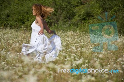 young Woman running In Meadow Stock Photo