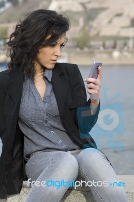 Young Woman Sends A Text Message Stock Photo