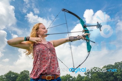 Young Woman Shooting Archery With Compound Bow And Arrow Stock Photo