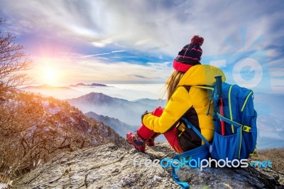 Young Woman Sitting On The Hill Of High Mountains Stock Photo