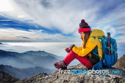 Young Woman Sitting On The Hill Of High Mountains Stock Photo