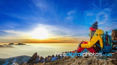 Young Woman Sitting On The Hill Of High Mountains Stock Photo