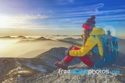 Young Woman Sitting On The Hill Of High Mountains Stock Photo