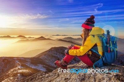 Young Woman Sitting On The Hill Of High Mountains Stock Photo